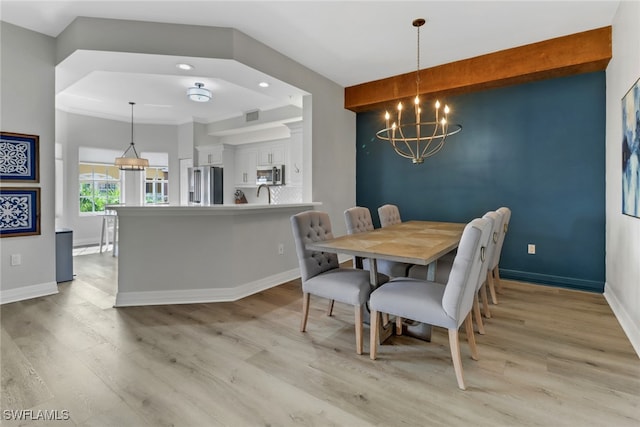 dining space with baseboards, visible vents, light wood-style flooring, and a chandelier