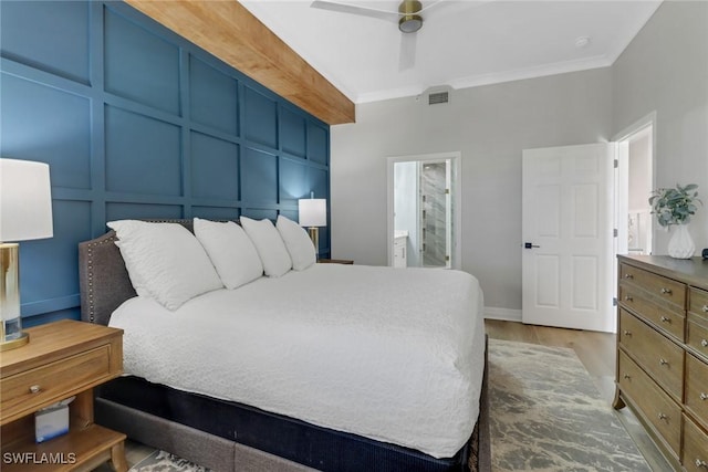 bedroom with ensuite bath, a ceiling fan, baseboards, visible vents, and ornamental molding