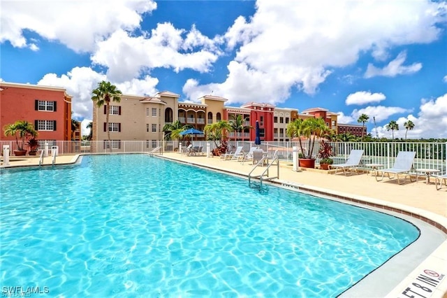 community pool with fence and a patio area