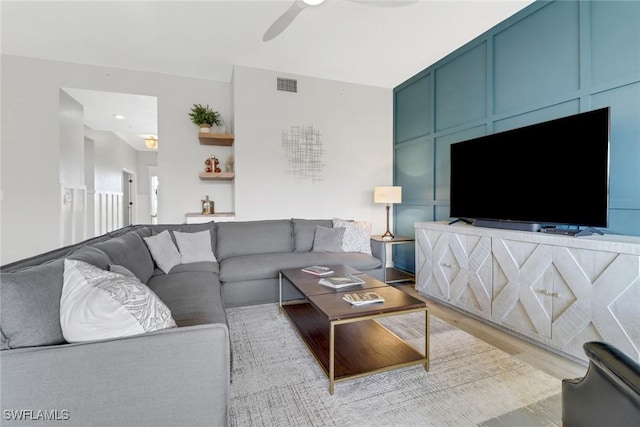 living room featuring ceiling fan, light wood-style flooring, and visible vents