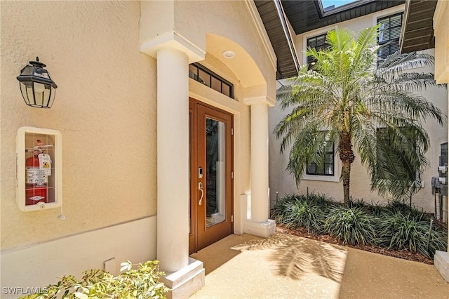 doorway to property featuring stucco siding