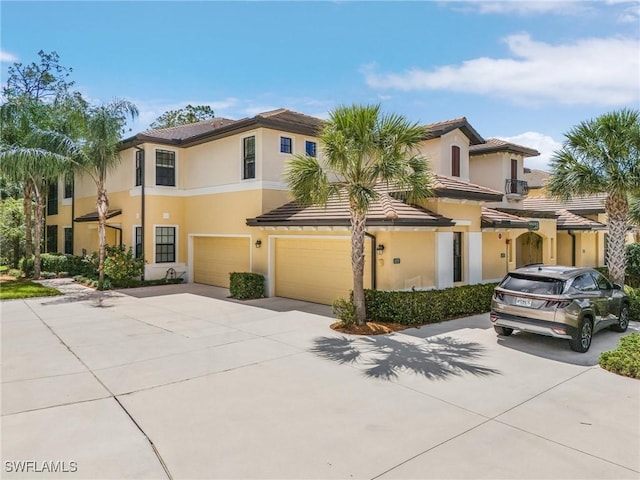 view of front facade featuring stucco siding, driveway, and a garage