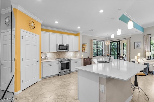 kitchen featuring white cabinets, backsplash, appliances with stainless steel finishes, and a sink