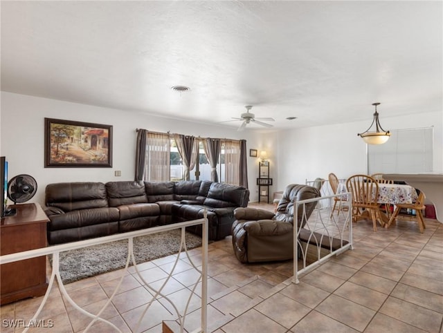 living area with light tile patterned floors, visible vents, and ceiling fan