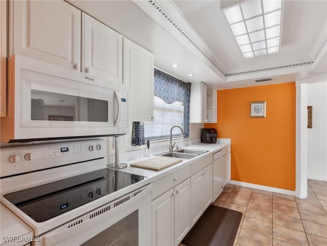 kitchen with a sink, white appliances, visible vents, white cabinetry, and baseboards