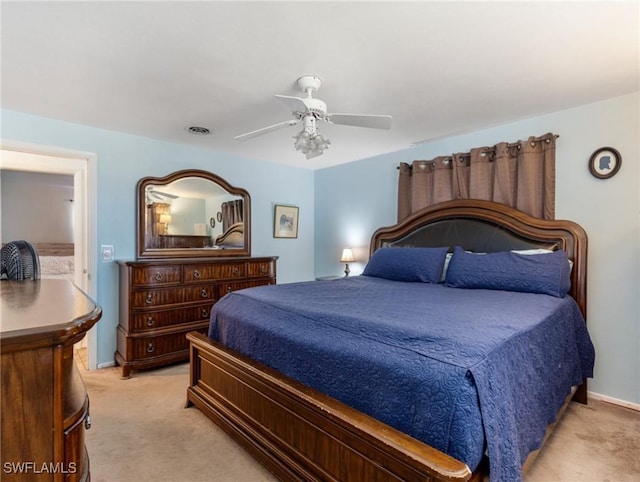bedroom featuring light colored carpet, visible vents, baseboards, and ceiling fan