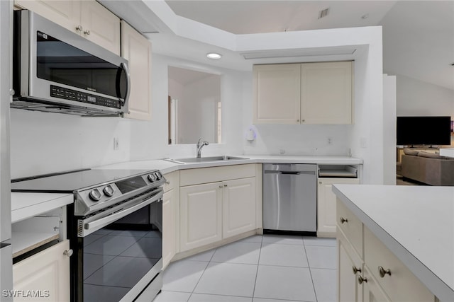 kitchen with light tile patterned floors, a sink, stainless steel appliances, visible vents, and light countertops