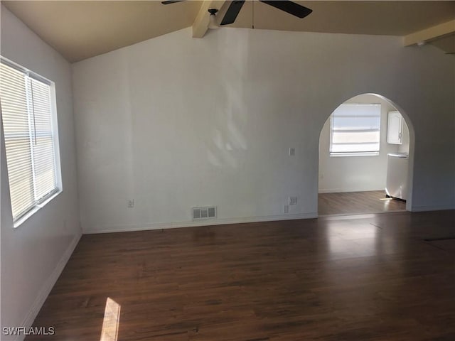 spare room featuring visible vents, wood finished floors, a ceiling fan, and vaulted ceiling with beams