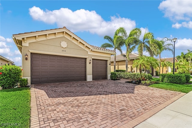 3454 Pacific Dr, Naples, FL 34119 - mediterranean / spanish-style home with decorative driveway, stucco siding, and a garage