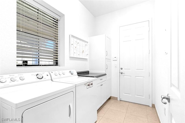 3454 Pacific Dr, Naples, FL 34119 - clothes washing area with washer and dryer, light tile patterned floors, and cabinet space