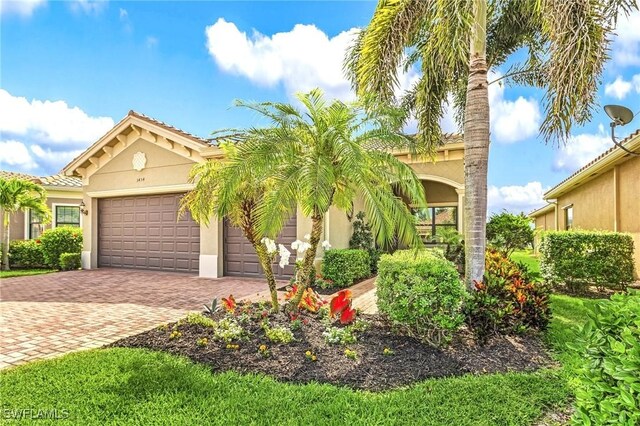 3454 Pacific Dr, Naples, FL 34119 - mediterranean / spanish house featuring decorative driveway, a garage, stucco siding, and a tiled roof
