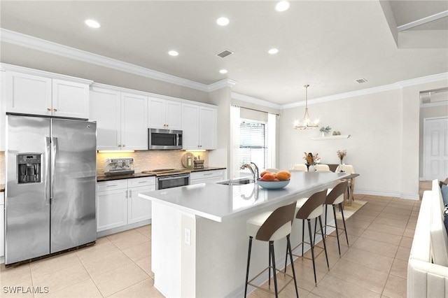3454 Pacific Dr, Naples, FL 34119 - kitchen with appliances with stainless steel finishes, light tile patterned floors, tasteful backsplash, a sink, and a kitchen island with sink