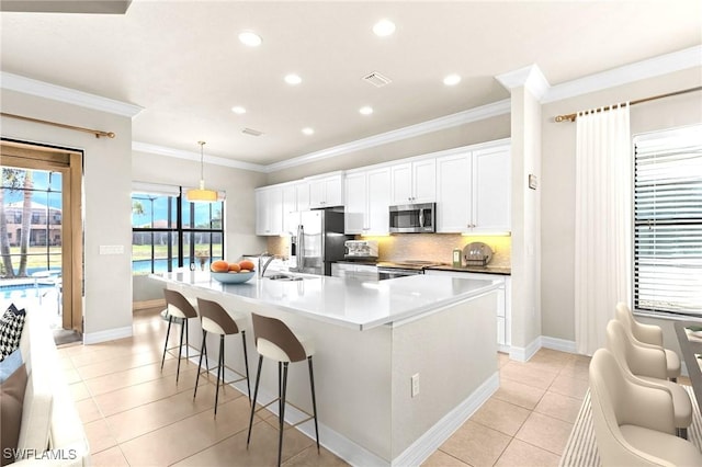 3454 Pacific Dr, Naples, FL 34119 - kitchen with stainless steel appliances, a sink, a large island with sink, ornamental molding, and white cabinetry
