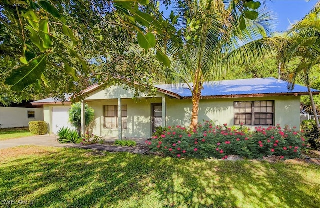 75 Hardee St, Labelle, FL 33935 - ranch-style house with stucco siding, a front yard, driveway, and a garage