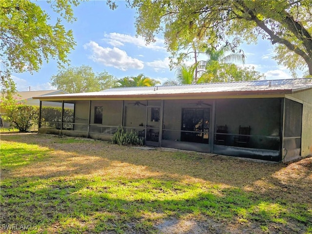 75 Hardee St, Labelle, FL 33935 - rear view of property featuring a sunroom, a ceiling fan, and a yard