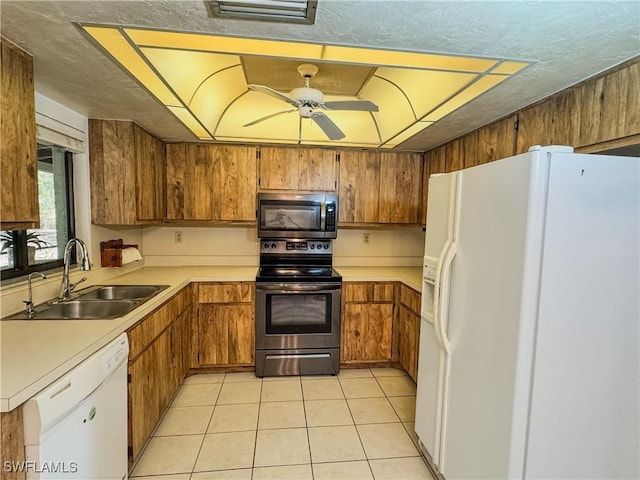 75 Hardee St, Labelle, FL 33935 - kitchen with appliances with stainless steel finishes, a sink, brown cabinetry, light countertops, and a ceiling fan