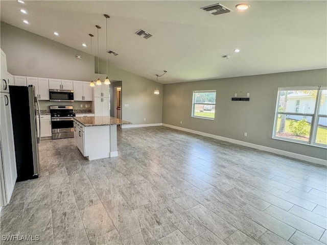 168 Village Cir Unit 9, Labelle, FL 33935 - kitchen featuring appliances with stainless steel finishes, lofted ceiling, white cabinetry, open floor plan, and a center island