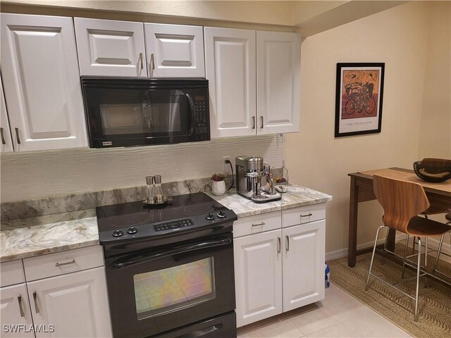 512 Sugar Pine Ln Unit 512, Naples, FL 34108 - kitchen with white cabinets, baseboards, light stone countertops, and black appliances