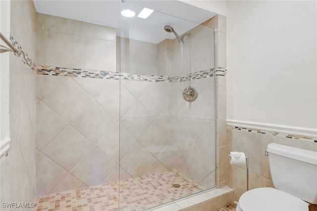 512 Sugar Pine Ln Unit 512, Naples, FL 34108 - bathroom featuring a stall shower, toilet, tile walls, and a wainscoted wall