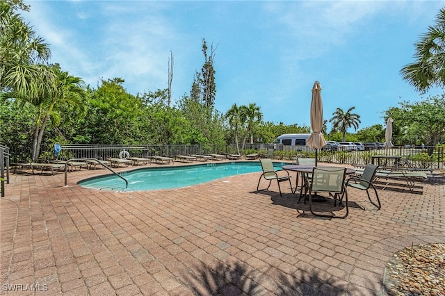 community pool featuring a patio and fence