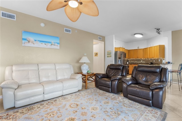 living area with light tile patterned floors, a ceiling fan, and visible vents