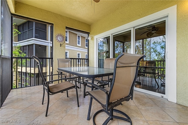 balcony with outdoor dining area and ceiling fan