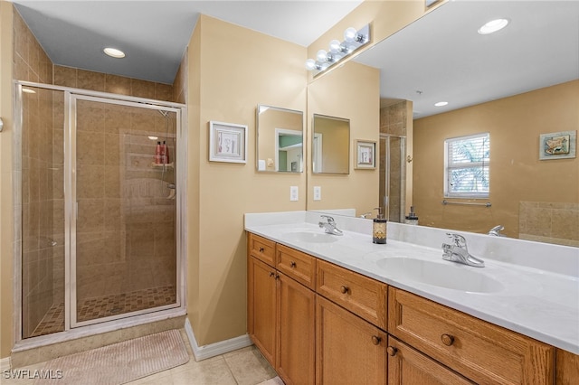 bathroom featuring a shower stall, tile patterned flooring, double vanity, and a sink