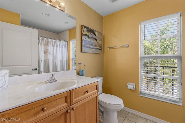 bathroom with vanity, a wealth of natural light, tile patterned flooring, and toilet
