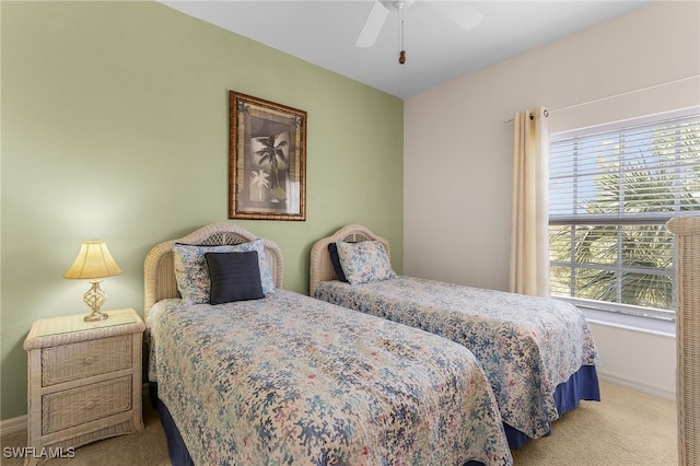 carpeted bedroom with baseboards, multiple windows, and a ceiling fan