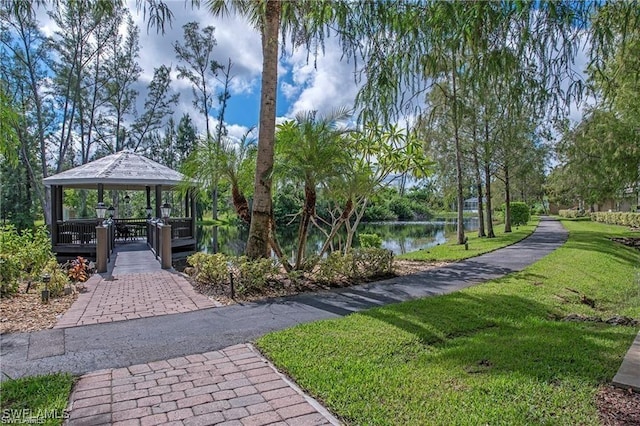 surrounding community with a water view, a gazebo, and a yard