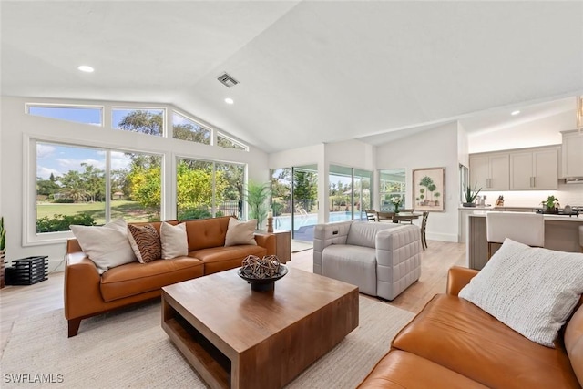 living area featuring high vaulted ceiling, light wood-type flooring, visible vents, and recessed lighting