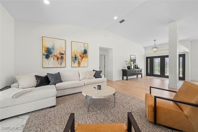 living room with light wood-style flooring, visible vents, baseboards, lofted ceiling, and recessed lighting