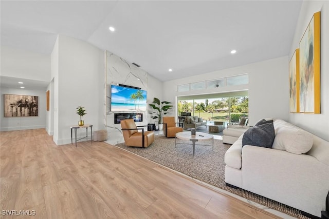 living area featuring recessed lighting, visible vents, high vaulted ceiling, and wood finished floors