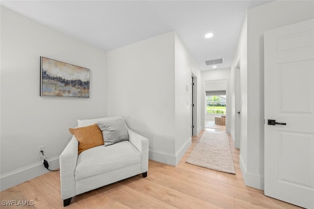 living area with baseboards, light wood-type flooring, visible vents, and recessed lighting