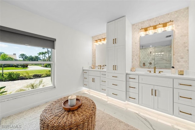 bathroom with vanity, visible vents, baseboards, and a stall shower