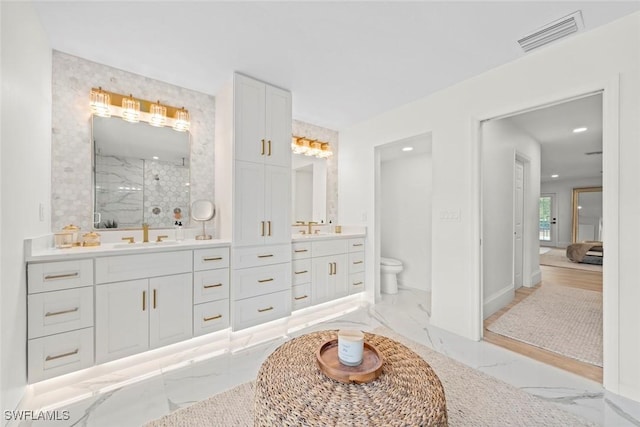 full bath featuring toilet, a stall shower, visible vents, marble finish floor, and vanity