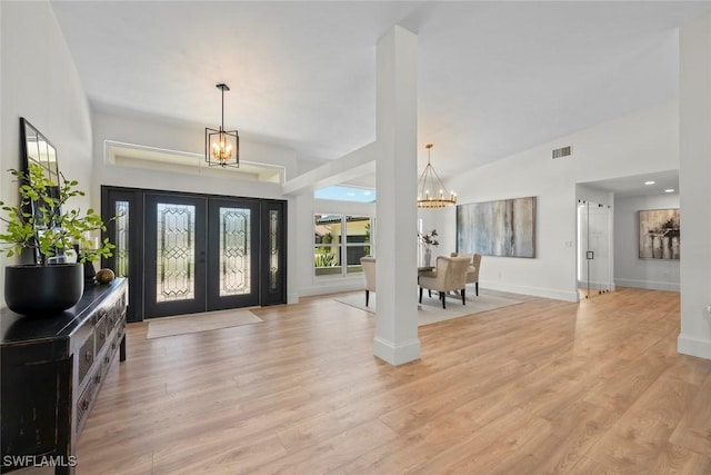 entrance foyer featuring french doors, high vaulted ceiling, light wood-type flooring, baseboards, and a chandelier