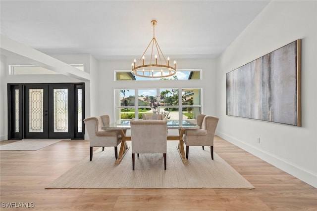 dining area with a notable chandelier, baseboards, french doors, and wood finished floors