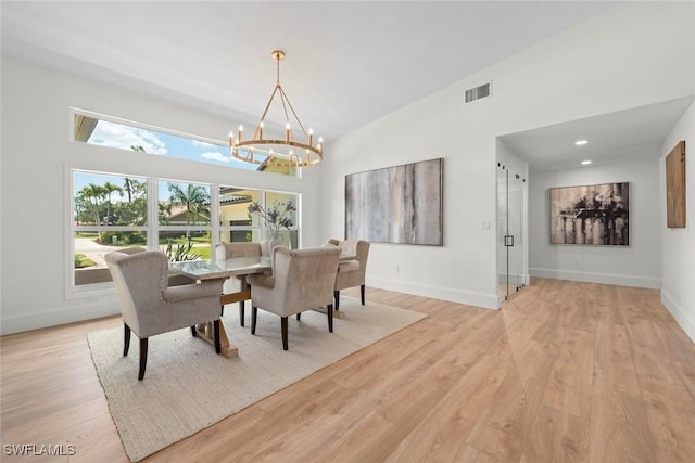 dining space with an inviting chandelier, baseboards, visible vents, and light wood-style floors