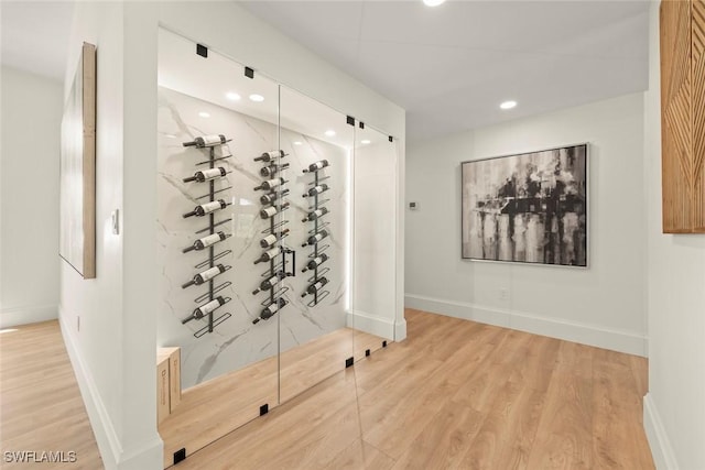 wine room featuring wood finished floors, baseboards, and recessed lighting