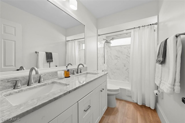 full bath featuring double vanity, toilet, wood finished floors, and a sink