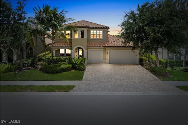 4437 Tamarind Way, Naples, FL 34119 - mediterranean / spanish home with a tiled roof, decorative driveway, stucco siding, an attached garage, and a lawn