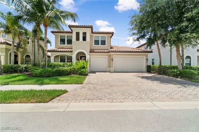 4437 Tamarind Way, Naples, FL 34119 - mediterranean / spanish home featuring stucco siding, decorative driveway, a tile roof, and a garage
