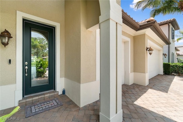4437 Tamarind Way, Naples, FL 34119 - doorway to property featuring stucco siding and a garage