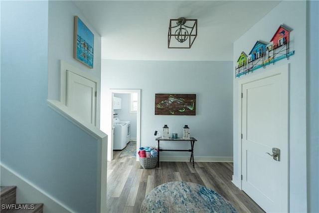 foyer entrance featuring independent washer and dryer, wood finished floors, and baseboards