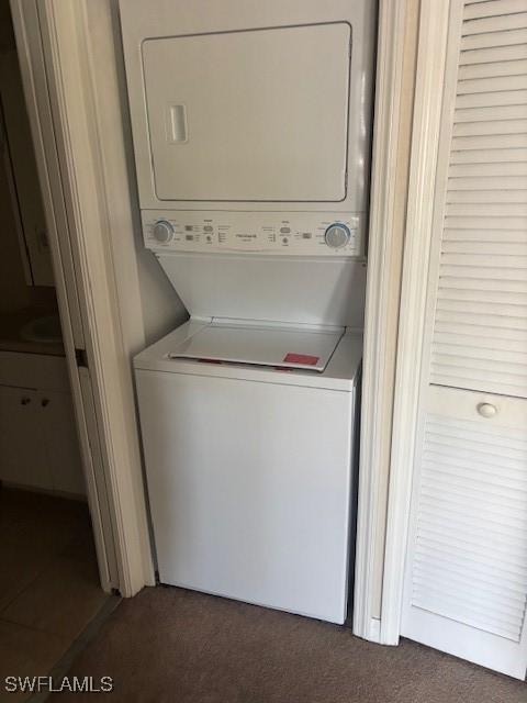 8326 Bernwood Cove Loop Unit 901, Fort Myers, FL 33966 - laundry room featuring stacked washer and clothes dryer and dark carpet