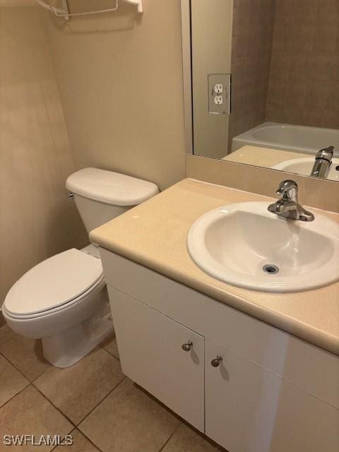 bathroom featuring tile patterned flooring, vanity, and toilet