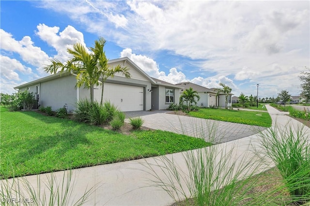 view of front facade with a front lawn, stucco siding, a garage, and decorative driveway