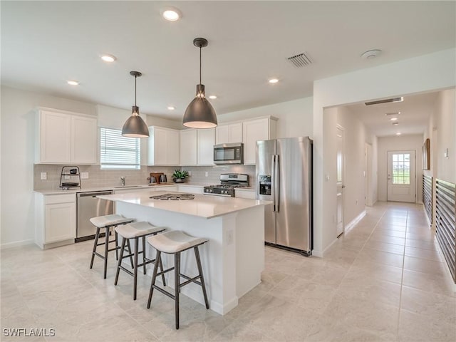 kitchen with tasteful backsplash, a kitchen island, plenty of natural light, and appliances with stainless steel finishes
