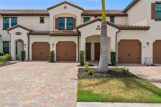 11792 Grand Belvedere Way Unit 202, Fort Myers, FL 33913 - mediterranean / spanish home featuring a garage, stucco siding, a tiled roof, and driveway
